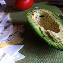 An avocado sliced to small cubes with a dull knive, so the skin stays intact