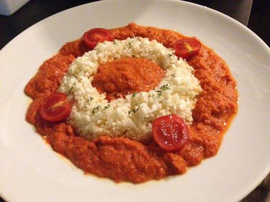 Cauliflower "rice" with a red peppers, carrot, avocado, parsley sauce with a touch of lemon juice and cocktail tomatoes as garnish