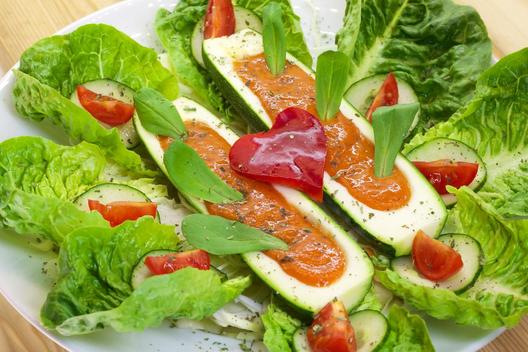 Banana - stuffed zucchini on leafy greens