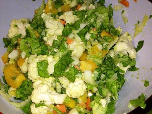 Salad with cauliflower, cicorie, green lettuce, yellow pepper, carrots, avocado and lemon juice.