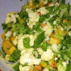 Salad with cauliflower, cicorie, green lettuce, yellow pepper, carrots, avocado and lemon juice.